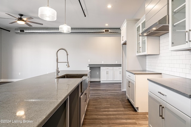 kitchen featuring dark hardwood / wood-style flooring, pendant lighting, white cabinets, and dark stone counters