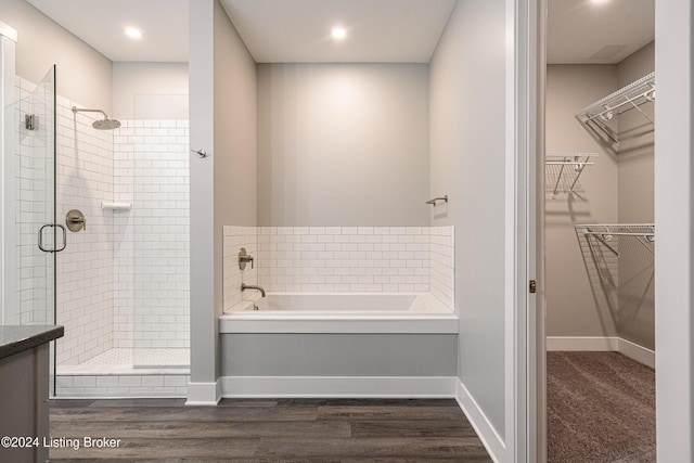 bathroom featuring separate shower and tub and wood-type flooring