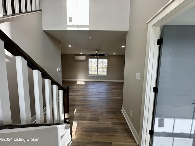 interior space featuring ceiling fan, dark wood-type flooring, and a wall unit AC