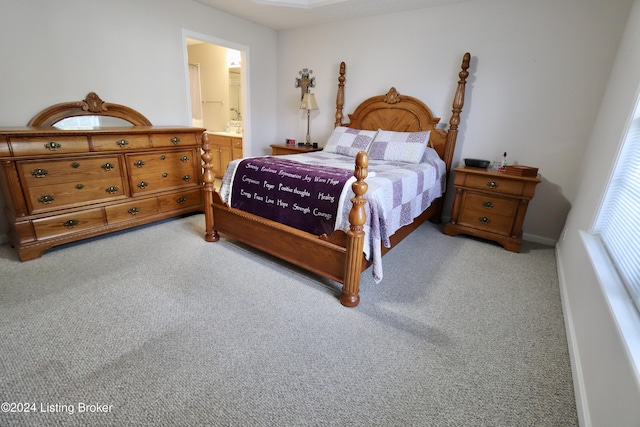 bedroom with light carpet and connected bathroom