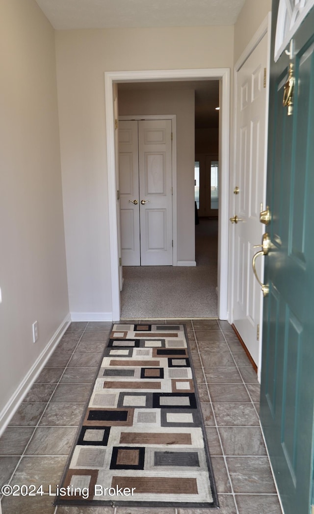 entryway with dark carpet