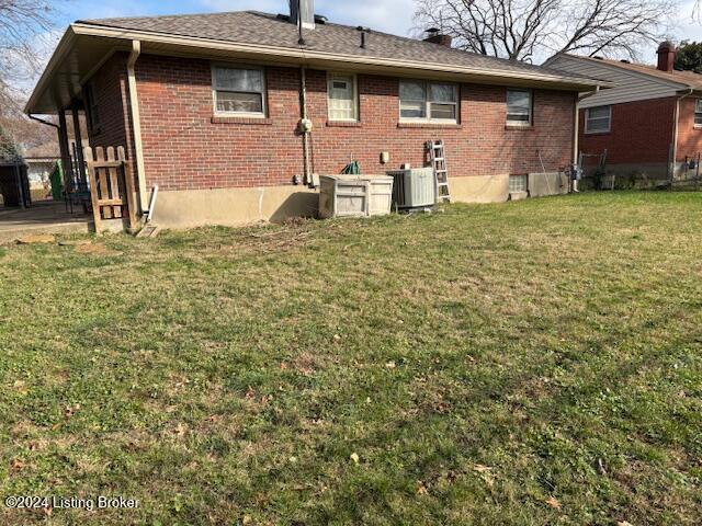 rear view of house featuring a yard and central AC unit