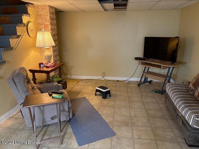 tiled living room featuring a drop ceiling