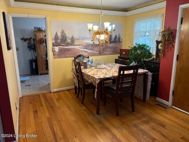 dining room with hardwood / wood-style floors, a textured ceiling, and an inviting chandelier