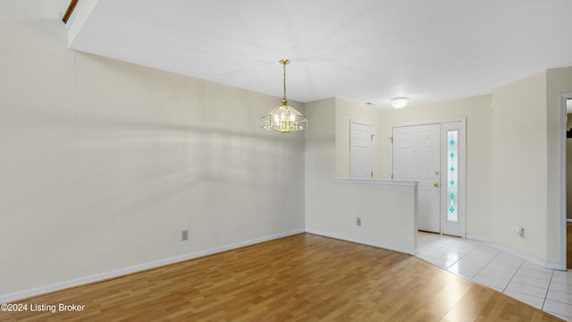 entrance foyer with a notable chandelier and light hardwood / wood-style flooring