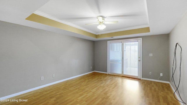 spare room with light hardwood / wood-style floors, a raised ceiling, ceiling fan, and crown molding