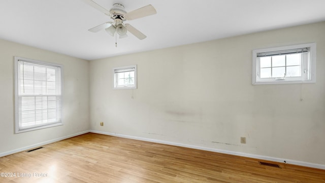 empty room with ceiling fan, light hardwood / wood-style floors, and a wealth of natural light