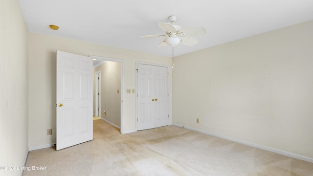 unfurnished bedroom featuring light carpet, a closet, and ceiling fan