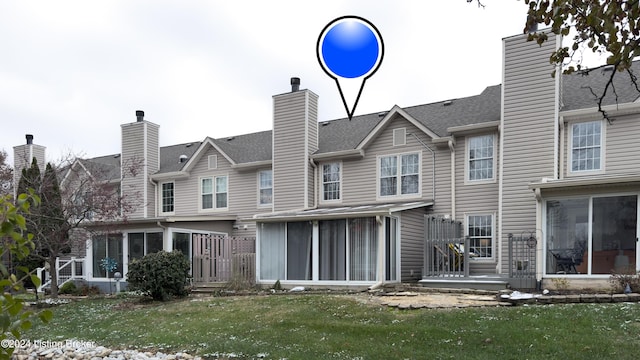 rear view of house with a sunroom and a lawn