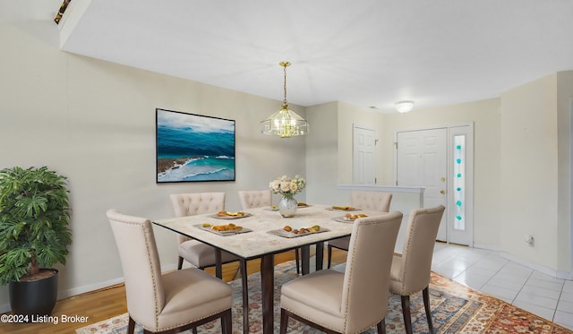 tiled dining room with a chandelier