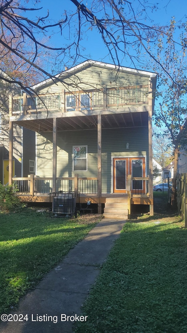 view of front facade featuring covered porch, a balcony, and a front yard