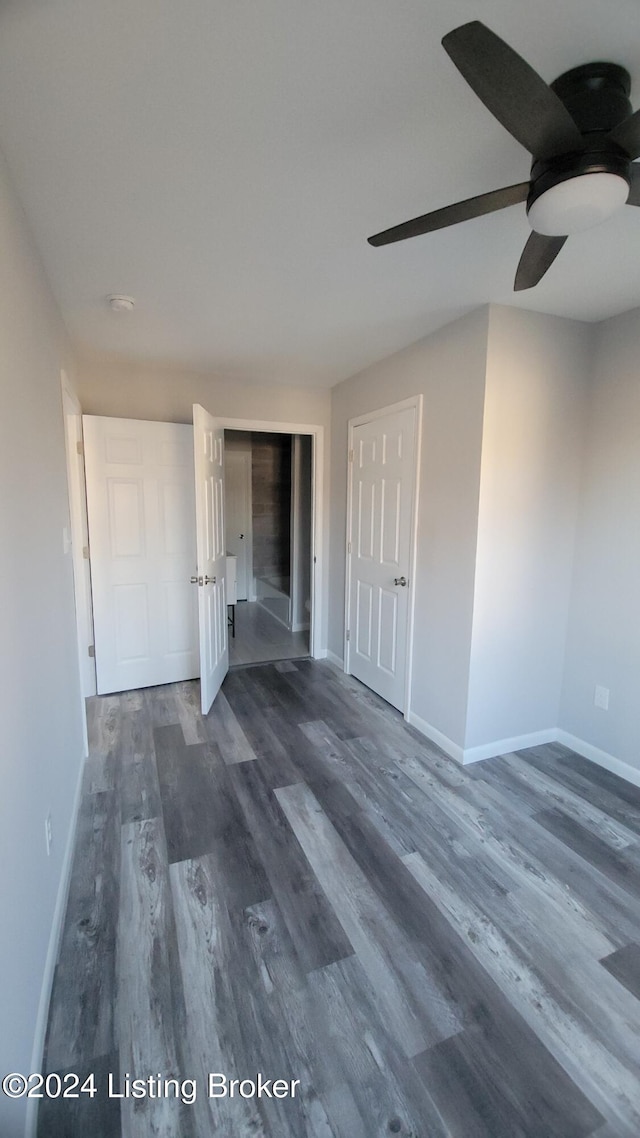 spare room featuring ceiling fan and dark wood-type flooring