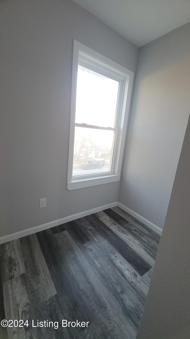 empty room with dark hardwood / wood-style flooring