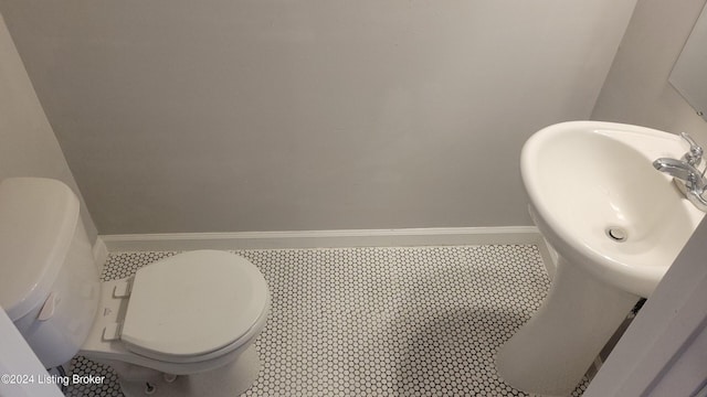 bathroom featuring tile patterned flooring, toilet, and sink