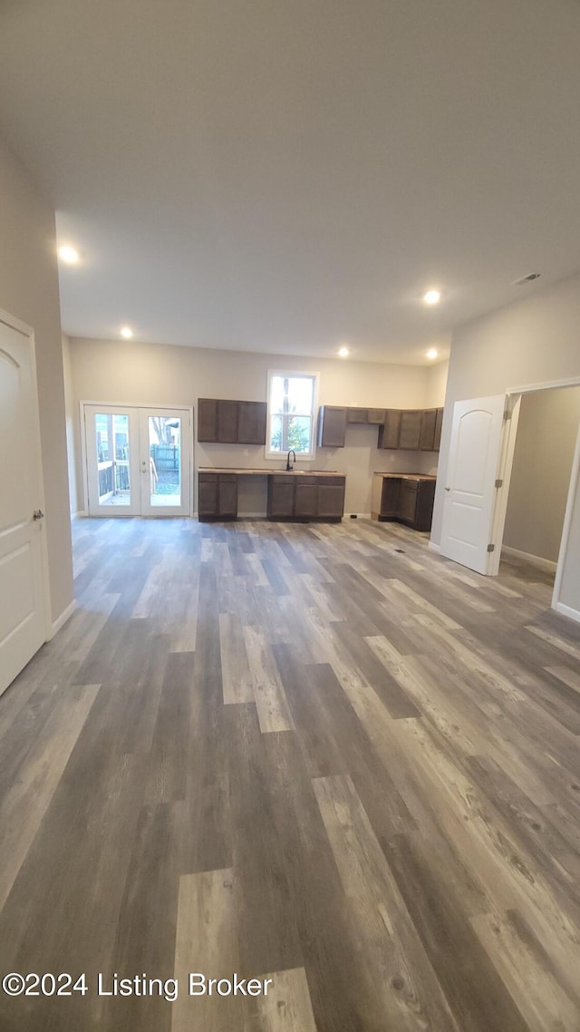 unfurnished living room with dark wood-type flooring and french doors