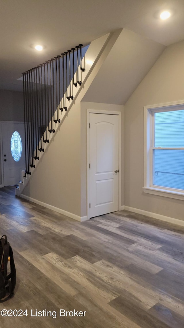 staircase featuring hardwood / wood-style flooring and lofted ceiling