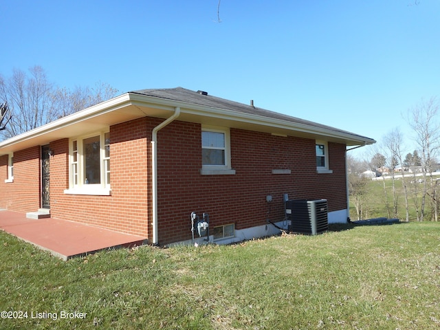 view of side of property with a yard and cooling unit