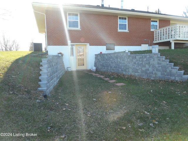 back of property with central air condition unit and a yard