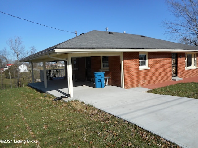 back of property featuring a carport and a yard