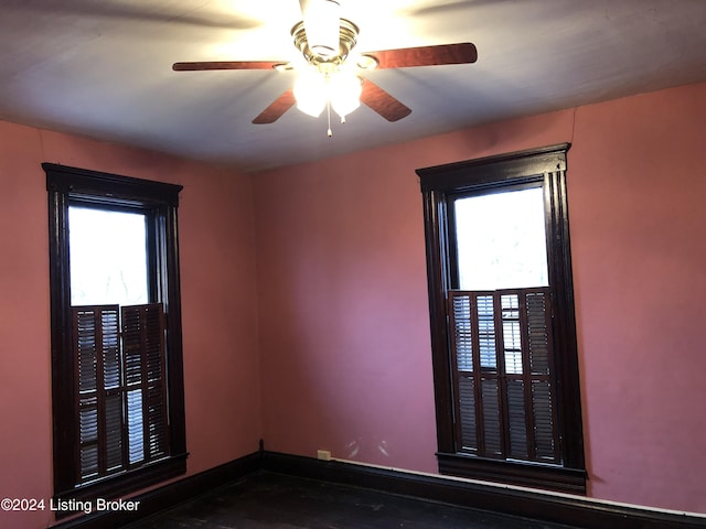 empty room with ceiling fan and baseboards