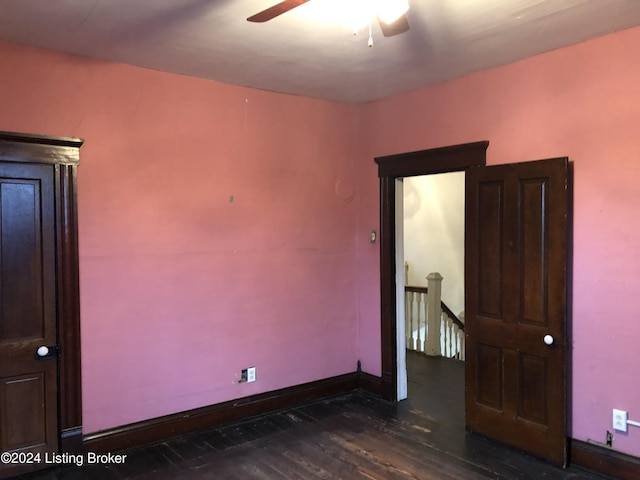 unfurnished room with baseboards, dark wood finished floors, and a ceiling fan