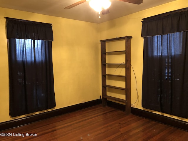 empty room featuring ceiling fan, baseboards, and wood finished floors