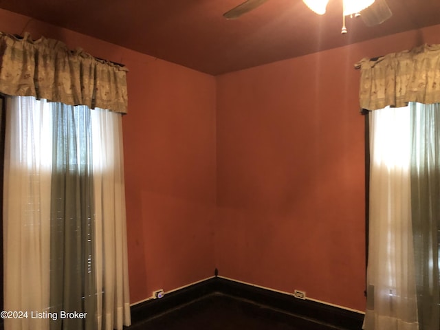 empty room with a ceiling fan and baseboards