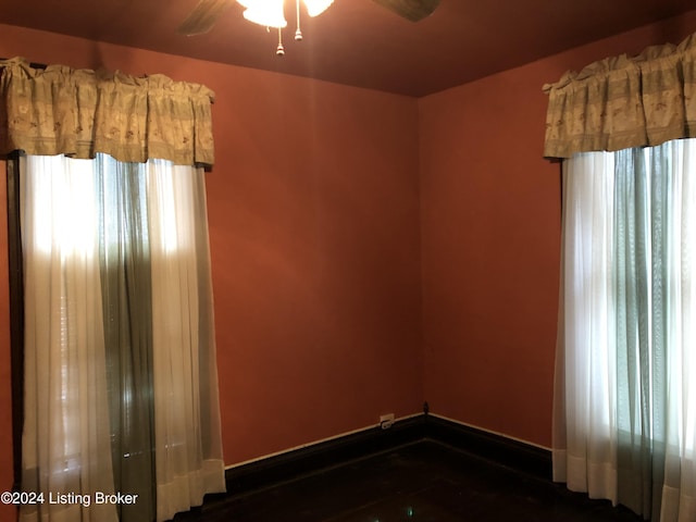 empty room featuring ceiling fan and baseboards