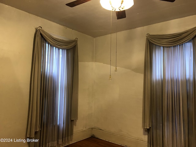 empty room with ceiling fan and dark wood-style flooring