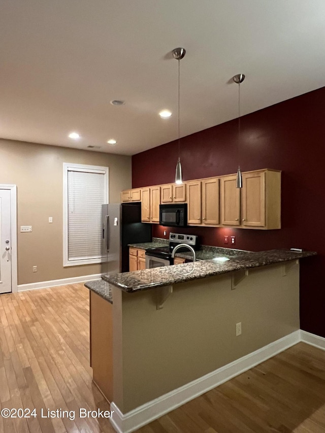 kitchen featuring a kitchen breakfast bar, kitchen peninsula, light hardwood / wood-style floors, decorative light fixtures, and appliances with stainless steel finishes