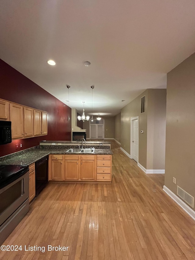 kitchen with light wood-type flooring, sink, black appliances, decorative light fixtures, and a notable chandelier