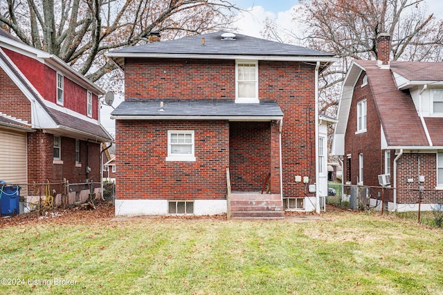 rear view of property featuring a yard and central AC unit