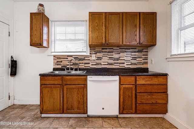 kitchen featuring white dishwasher, tasteful backsplash, and sink