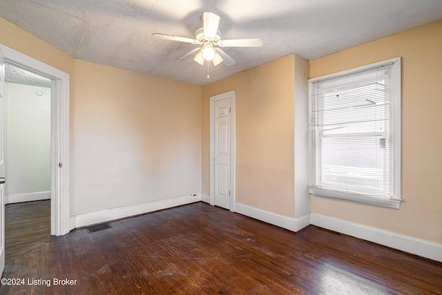 unfurnished room with ceiling fan, dark hardwood / wood-style flooring, and a textured ceiling