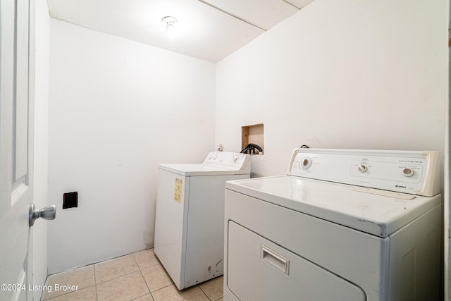 clothes washing area with light tile patterned floors and separate washer and dryer