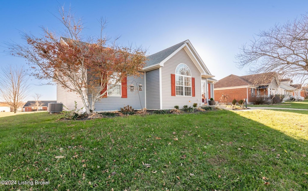 view of front of house with a front yard and cooling unit