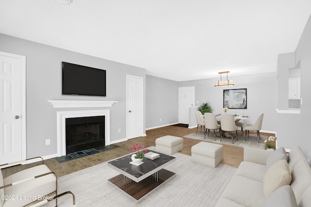 living room featuring wood-type flooring and an inviting chandelier