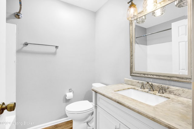 bathroom featuring hardwood / wood-style floors, vanity, toilet, and a shower