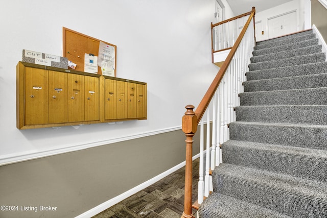 stairs featuring hardwood / wood-style floors and mail boxes