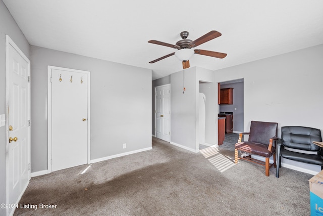 living area featuring carpet and ceiling fan