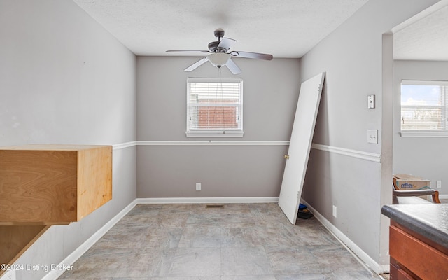 spare room featuring a textured ceiling and ceiling fan