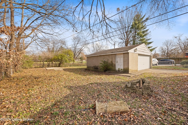 view of yard with a garage and an outbuilding