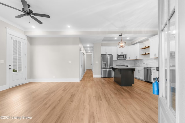 kitchen featuring a center island, stainless steel appliances, light hardwood / wood-style flooring, pendant lighting, and white cabinets