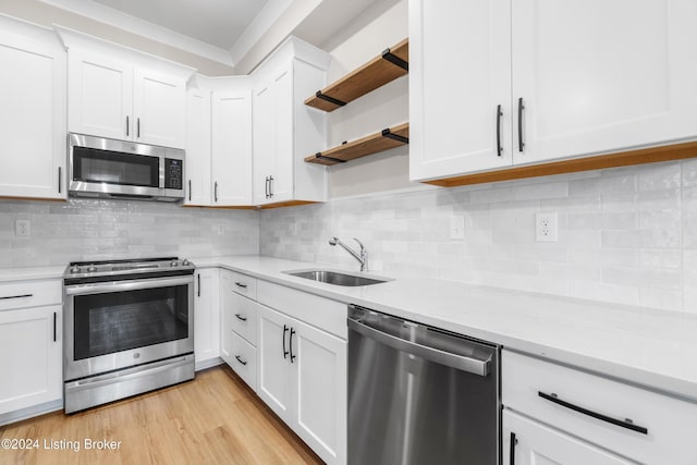 kitchen featuring white cabinets, stainless steel appliances, light hardwood / wood-style floors, and sink