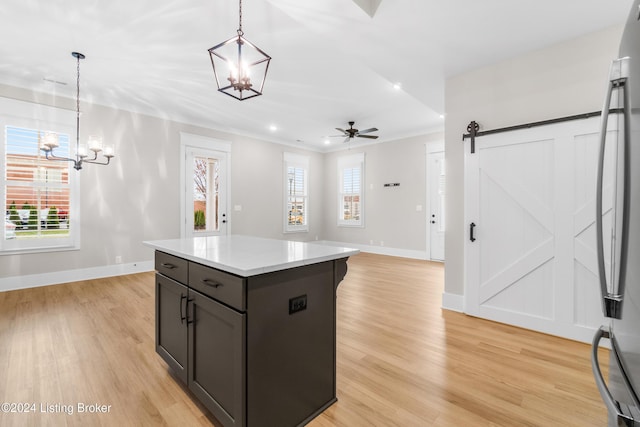 kitchen featuring pendant lighting, a barn door, and plenty of natural light