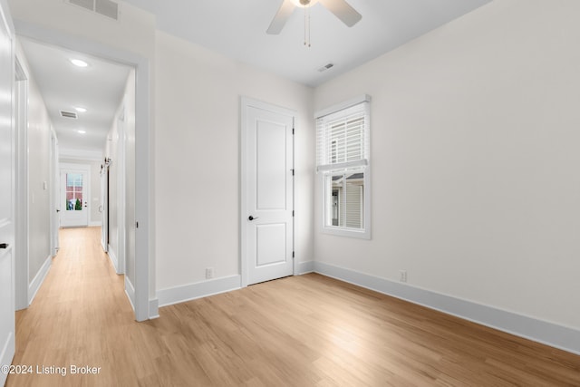 empty room with ceiling fan and light hardwood / wood-style floors