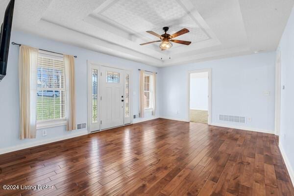 unfurnished room with dark hardwood / wood-style floors, ceiling fan, and a raised ceiling