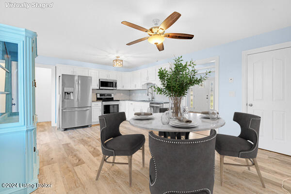 dining space featuring light wood-type flooring, ceiling fan, and sink