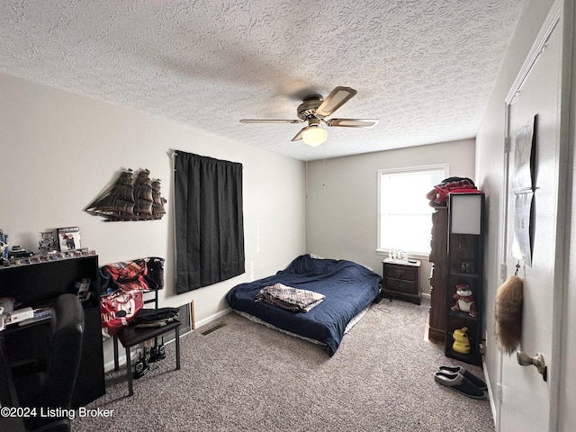 bedroom with carpet, ceiling fan, and a textured ceiling