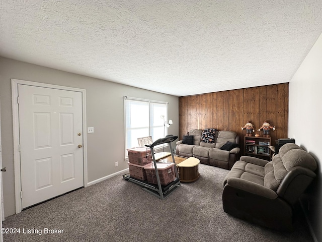 carpeted living room featuring a textured ceiling and wood walls